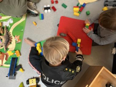 Børn, der leger med lego på gulvet.
